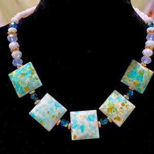 Handmade necklace with teal, white and gold beads.